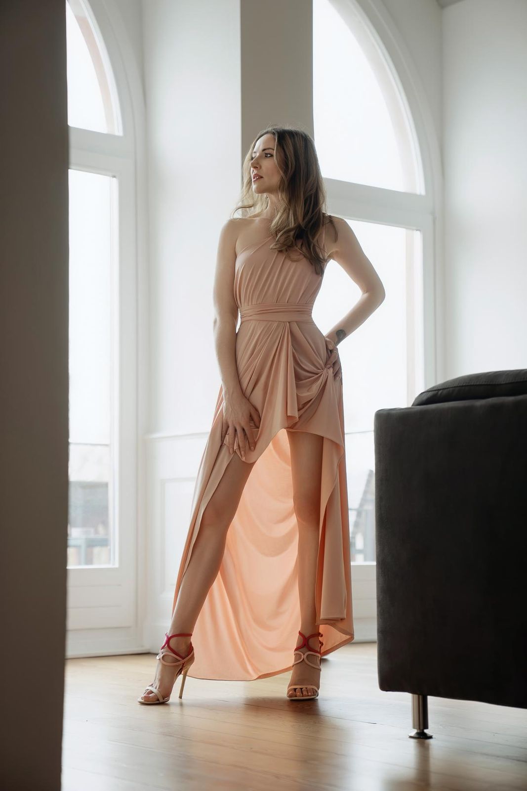 Irina le Fey im apricotfarbenen Abendkleid vor Bogenfenstern
