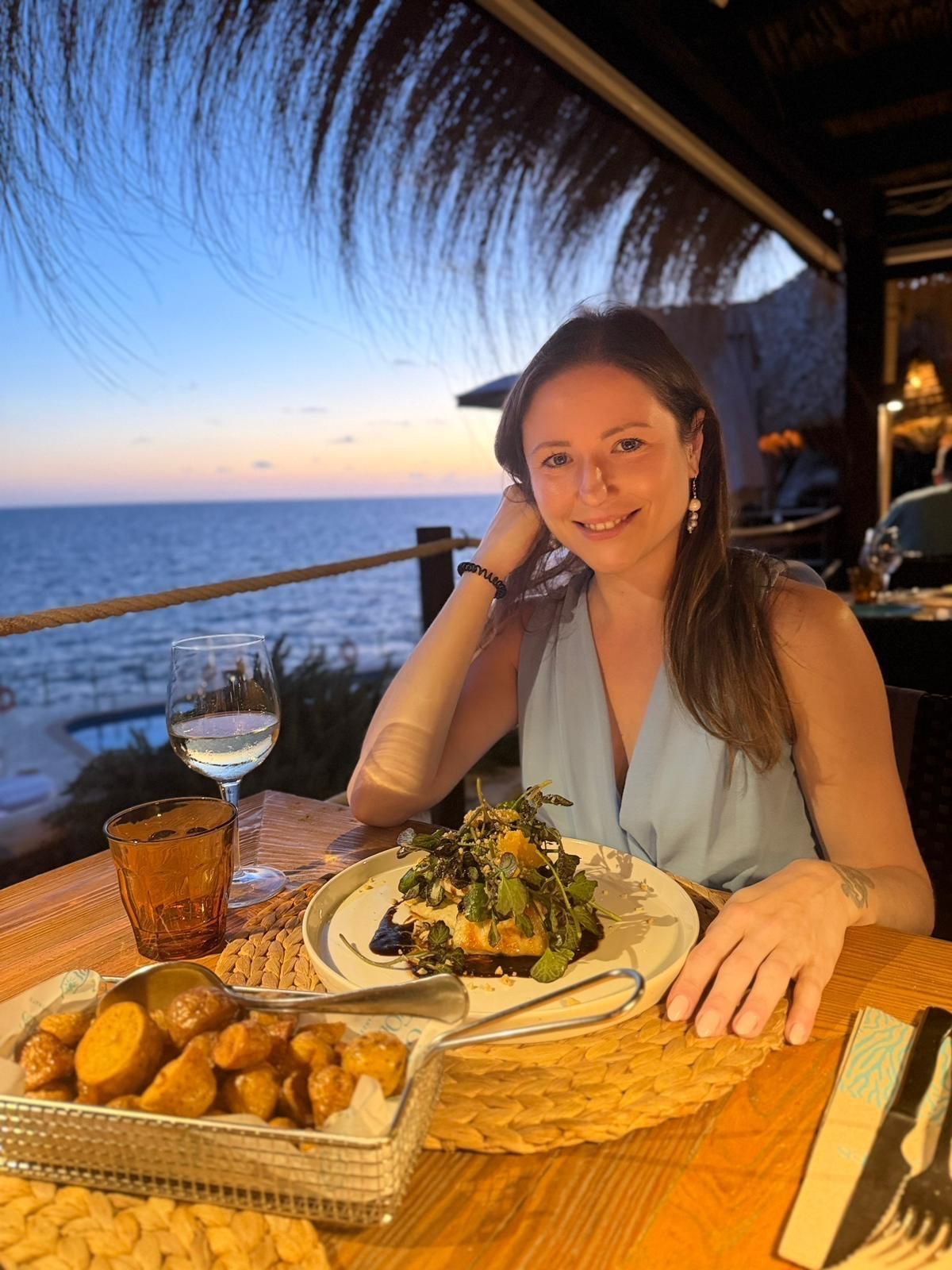 Irina le Fey beim Dinner am Meer bei Sonnenuntergang