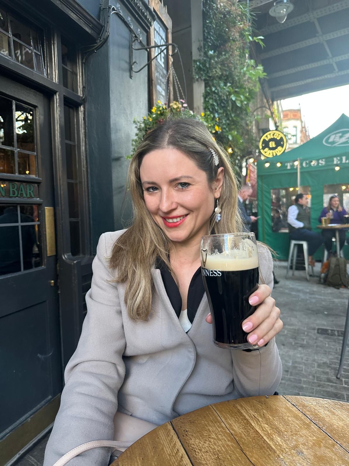 Irina le Fey mit einem Glas Guinness vor einem Pub
